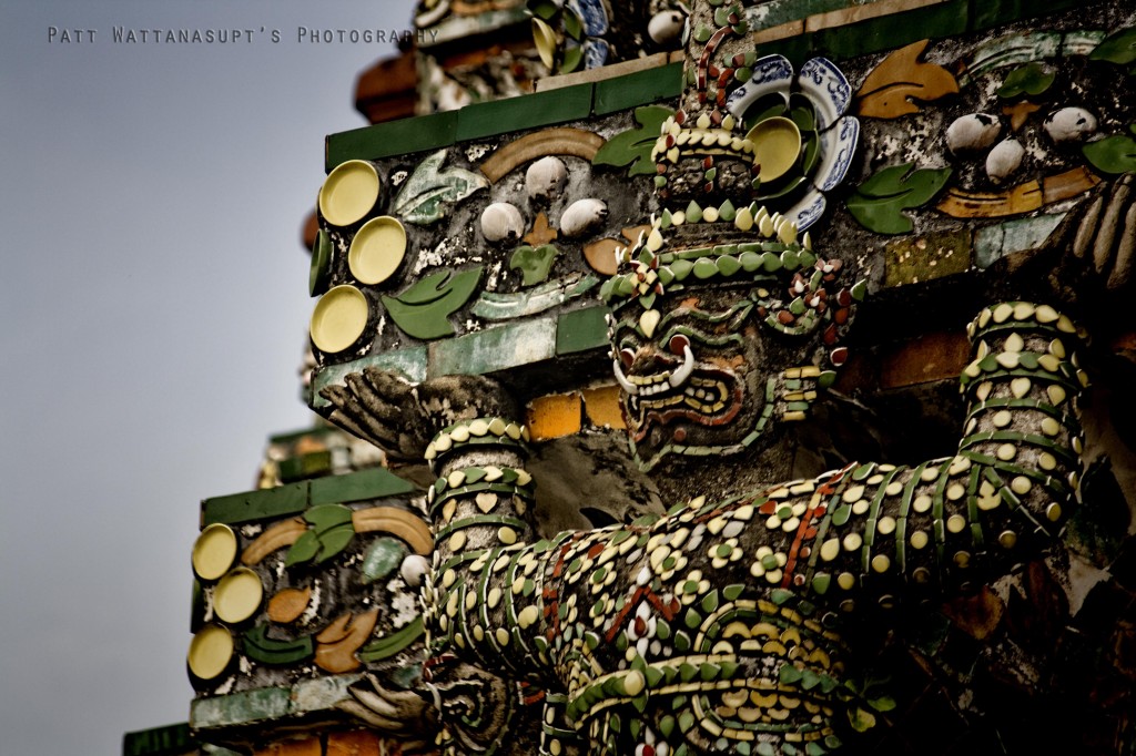 Giand figures at the base of stupa, as if they are holding the stupa up.